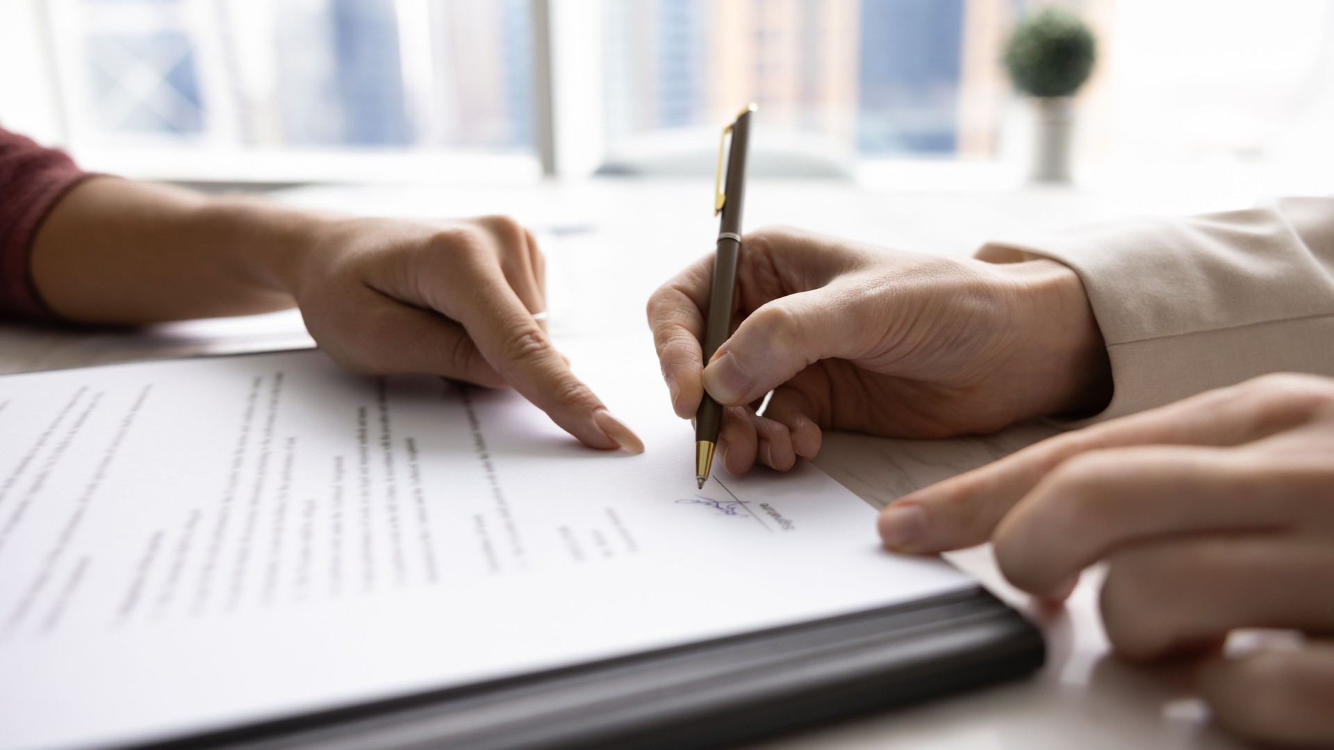 Hands close up of buyer and seller signing agreement